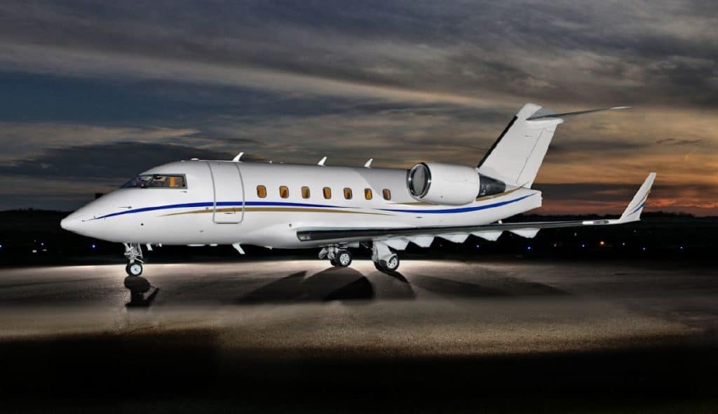 Exterior of Challenger 605 heavy luxury private jet on runway at dusk.