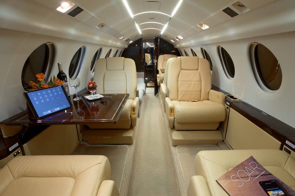 Interior of Falcon 50 private jet aircraft with wine, entertainment and snacks.